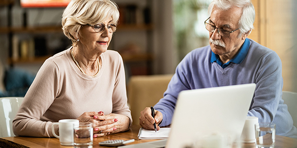 Mature couple using computer while planning their home budget